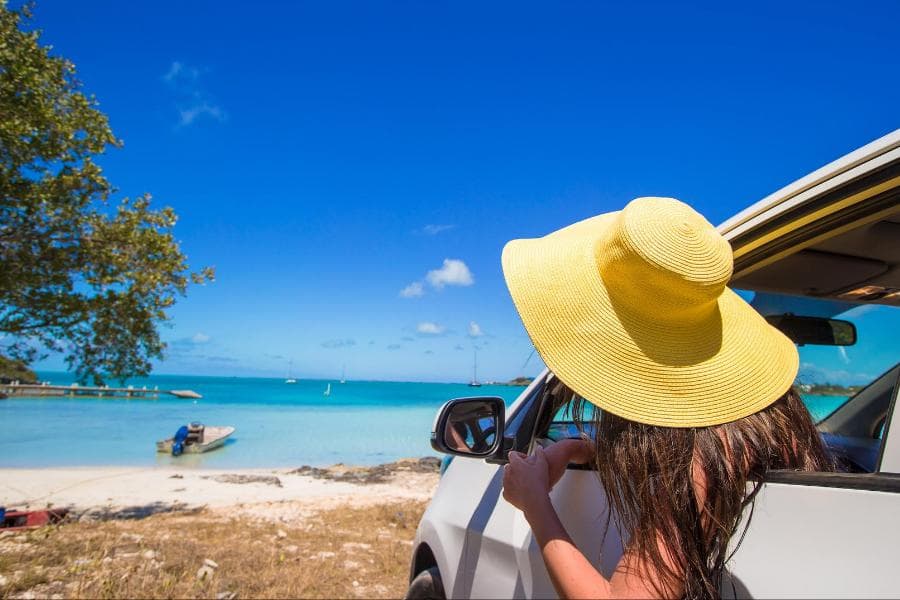 Viajera disfrutando el mar Caribe desde su auto de renta